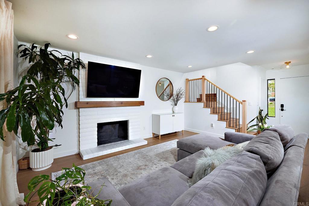 214 Calle De Madera Encinitas, CA 92024 - Photo 3 of 25 a living room with furniture a flat screen tv and a fireplace