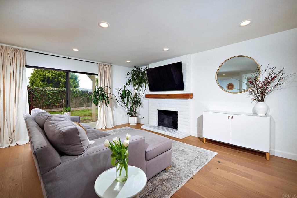 214 Calle De Madera Encinitas, CA 92024 - Photo 5 of 25 a living room with furniture a fireplace and a floor to ceiling window
