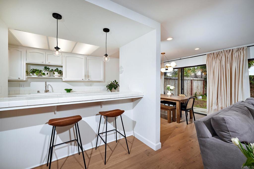 214 Calle De Madera Encinitas, CA 92024 - Photo 10 of 25 a kitchen with stainless steel appliances granite countertop a table chairs sink and cabinets