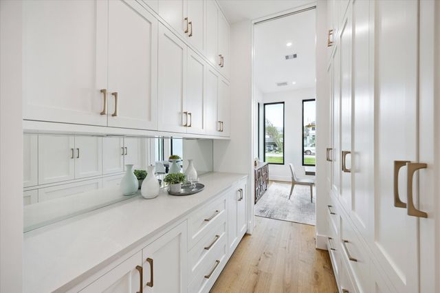 a kitchen with white cabinets and window