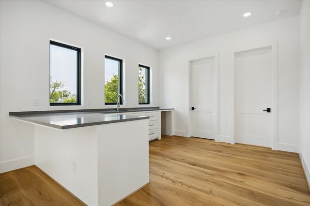 a view of a hallway with wooden floor and cabinet