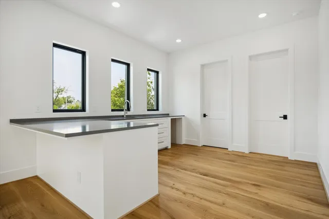 a view of a hallway with wooden floor and cabinet