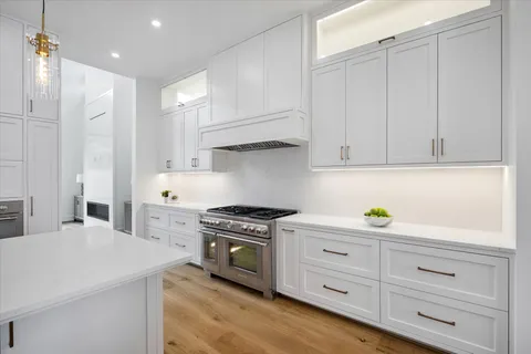 a kitchen with white cabinets and appliances