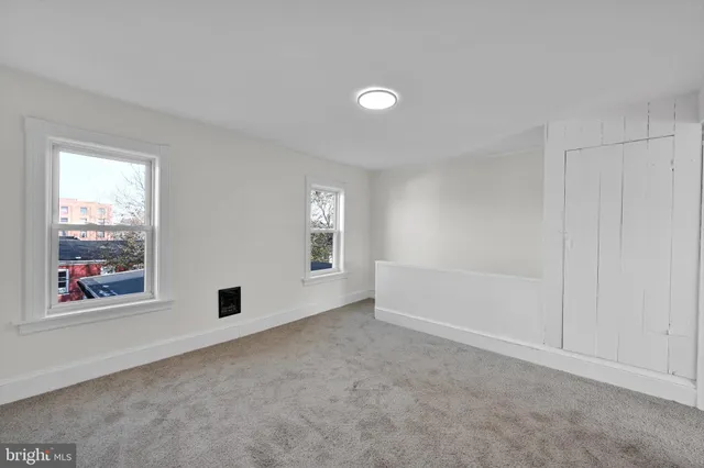 an empty room with windows and closet