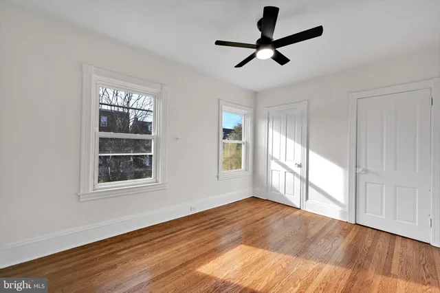 a view of empty room with wooden floor and window