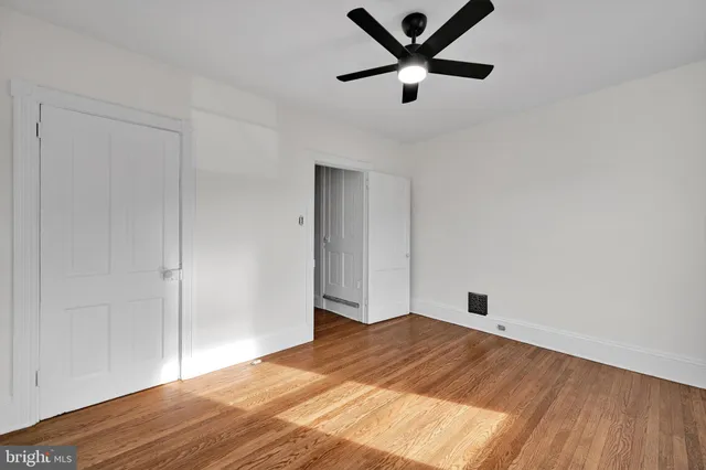 a view of a big room with wooden floor and a ceiling fan