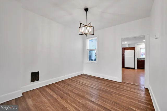a view of a hallway with wooden floor and a chandelier