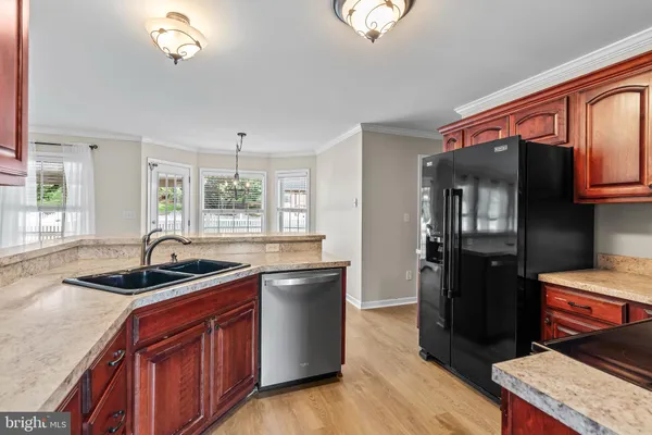 a kitchen with stainless steel appliances granite countertop a sink and a refrigerator