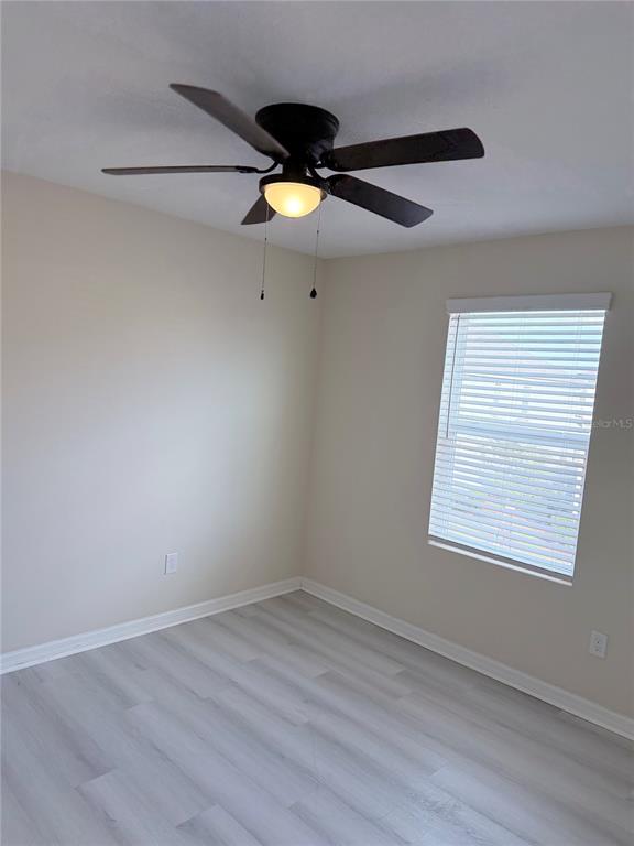 9463 Randal Park Boulevard Orlando, FL 32832 - Photo 14 of 25 an empty room with wooden floor and fan
