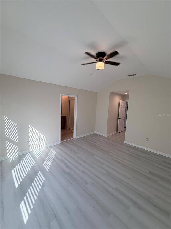 9463 Randal Park Boulevard Orlando, FL 32832 - Photo 17 of 25 a view of an empty room with wooden floor and a ceiling fan