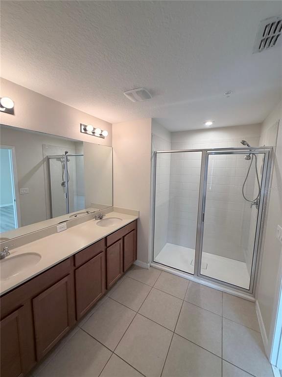 9463 Randal Park Boulevard Orlando, FL 32832 - Photo 19 of 25 a bathroom with a granite countertop sink a mirror and a shower