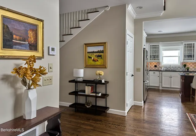 a view of hallway with furniture and wooden floor