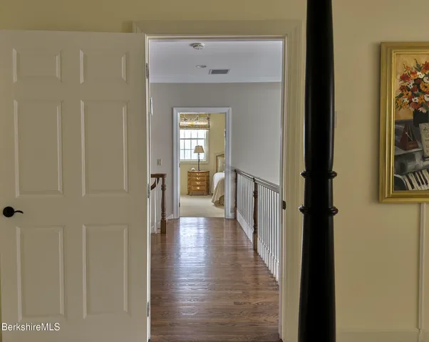 a view of a hallway with wooden floor and closet