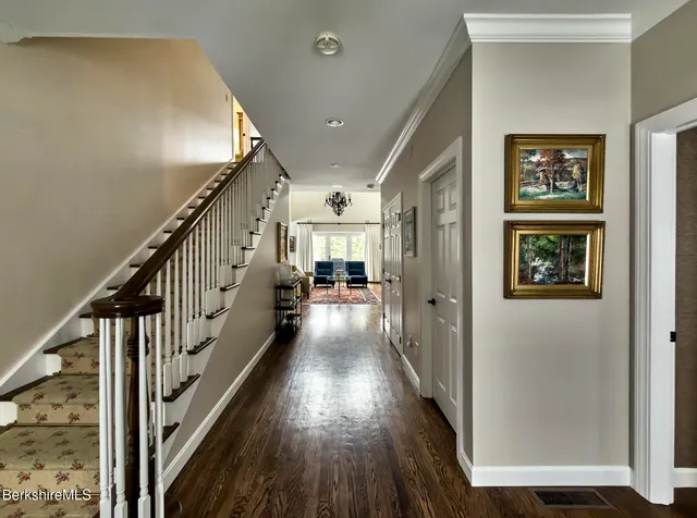 a view of a hallway with wooden floor and staircase