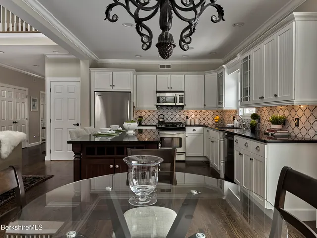 a kitchen with kitchen island granite countertop a sink cabinets and stainless steel appliances