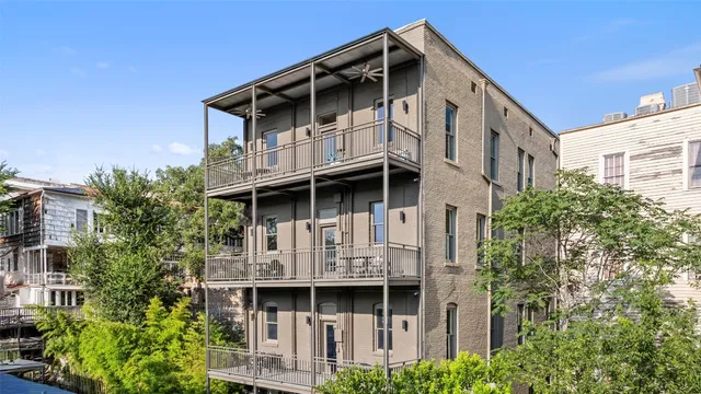 a view of house with large windows and plants