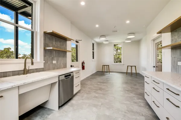 a large white kitchen with a large window