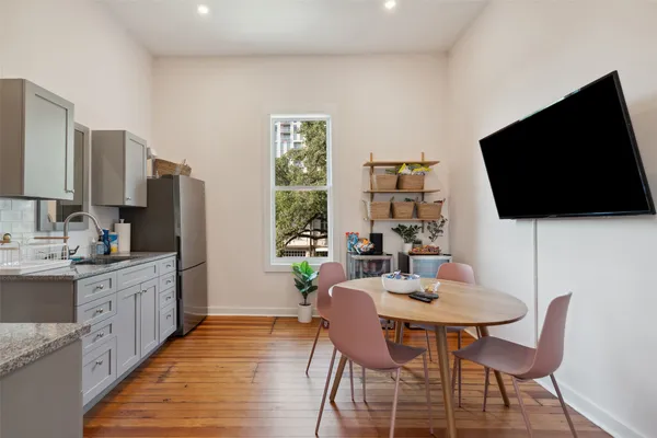 a kitchen with stainless steel appliances a dining table and chairs