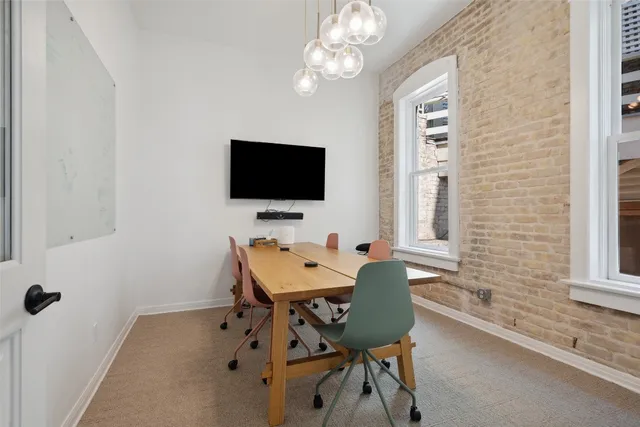 a view of a workspace with furniture and a window