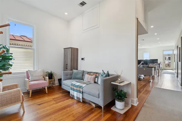 a living room with furniture and a wooden floor