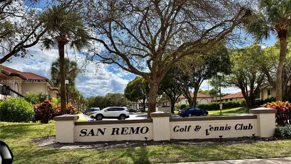 a view of sign board with large trees