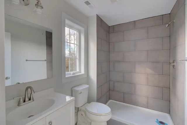 a bathroom with a sink a toilet and shower