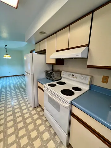 a kitchen with a stove a refrigerator and cabinets