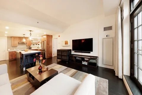a living room with furniture and a floor to ceiling window