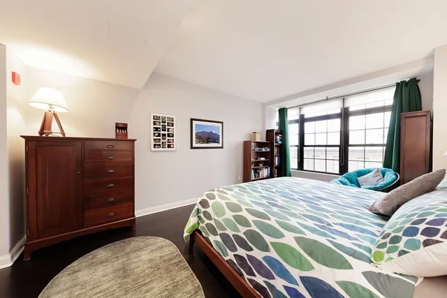 a bedroom with a bed a dresser and a book shelf