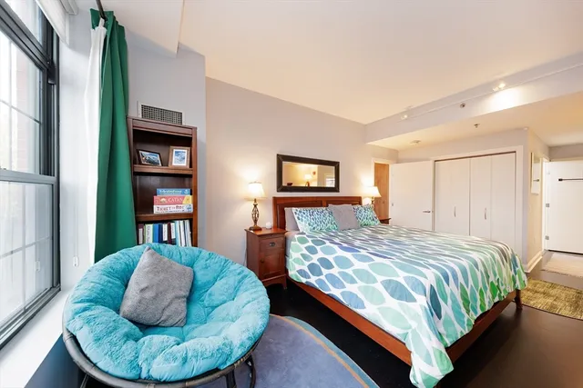 a bedroom with a bed and a large window