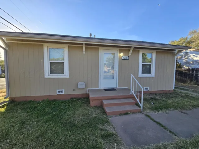 a view of a house with backyard and porch