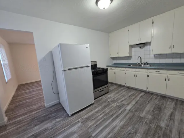 a kitchen with wooden floors and white appliances