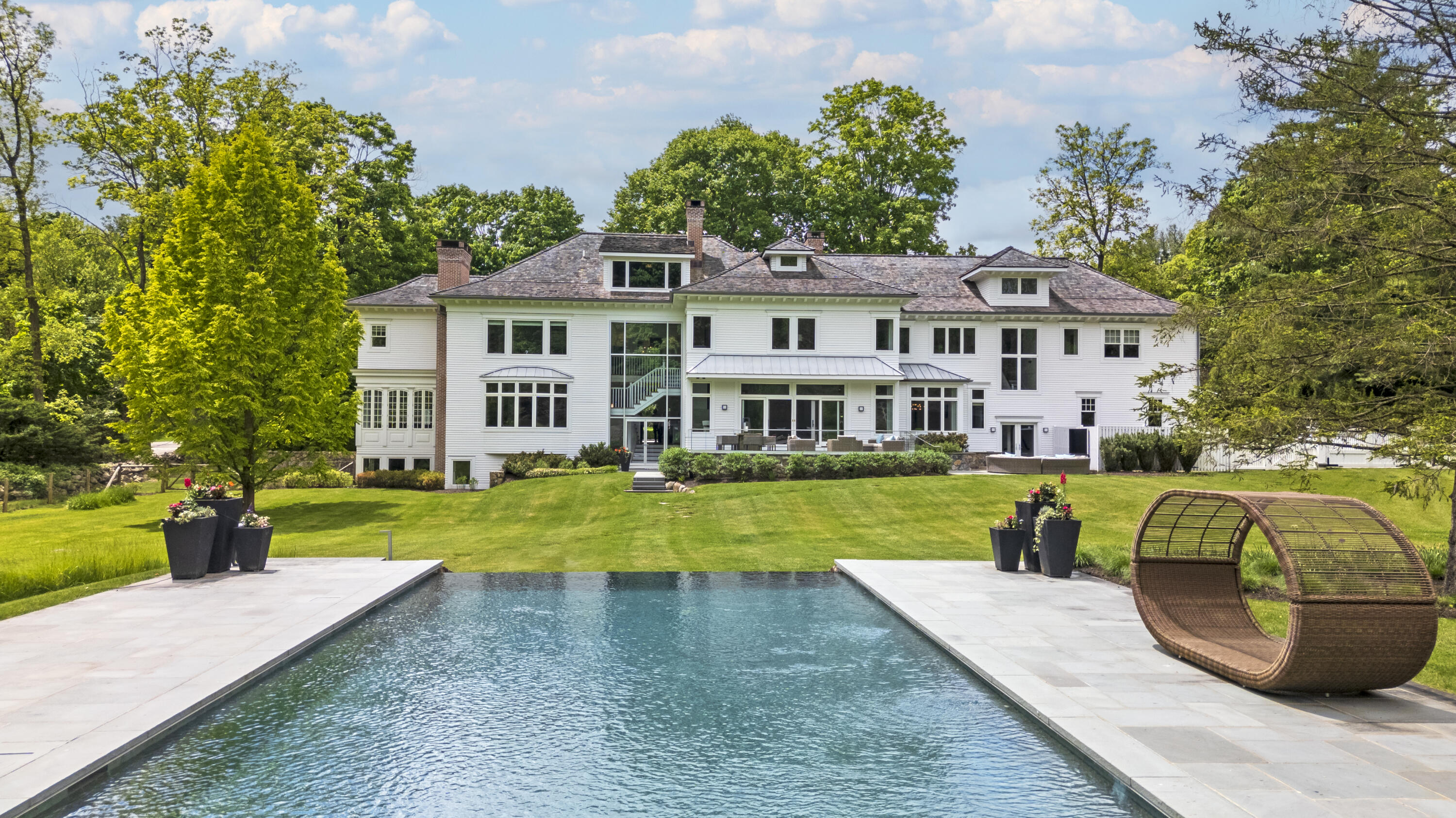 549 Oenoke Ridge New Canaan, CT 06840 - Photo 43 of 54 a front view of a house with garden