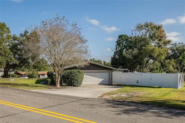 a view of a house with a yard and tree s
