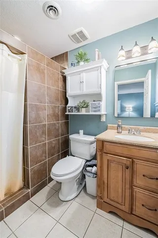a bathroom with a granite countertop toilet sink and mirror
