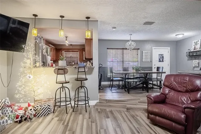 a living room with furniture a flat screen tv and kitchen view