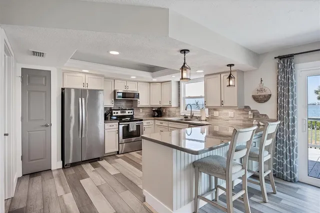 a kitchen with cabinets and chairs