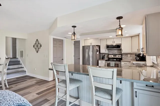 a kitchen with a sink stove cabinets and refrigerator
