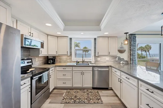 a kitchen with white cabinets and appliances