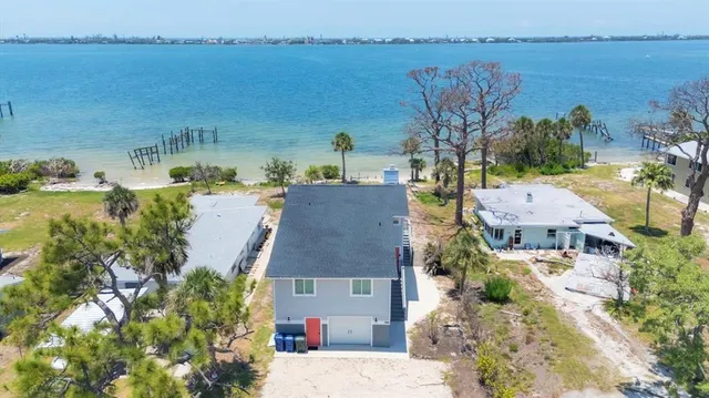 a aerial view of a house with outdoor space and lake view