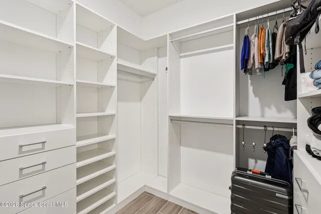 a view of walk in closet with clothes and shoes