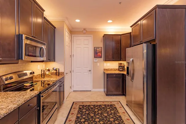 a kitchen with stainless steel appliances granite countertop a refrigerator stove and sink