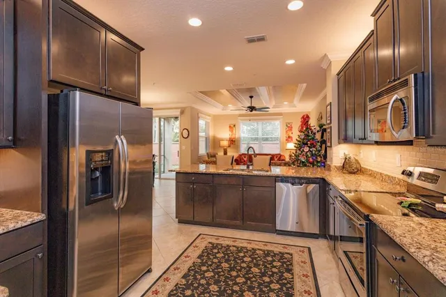 a kitchen with granite countertop stainless steel appliances and wooden cabinets