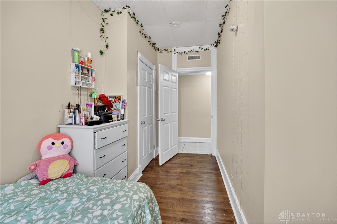 7045-7049 Montgomery Road Cincinnati, OH 45236 - Photo 51 of 68 This cozy bedroom features durable hardwood flooring and a classic door, offering comfortable living.