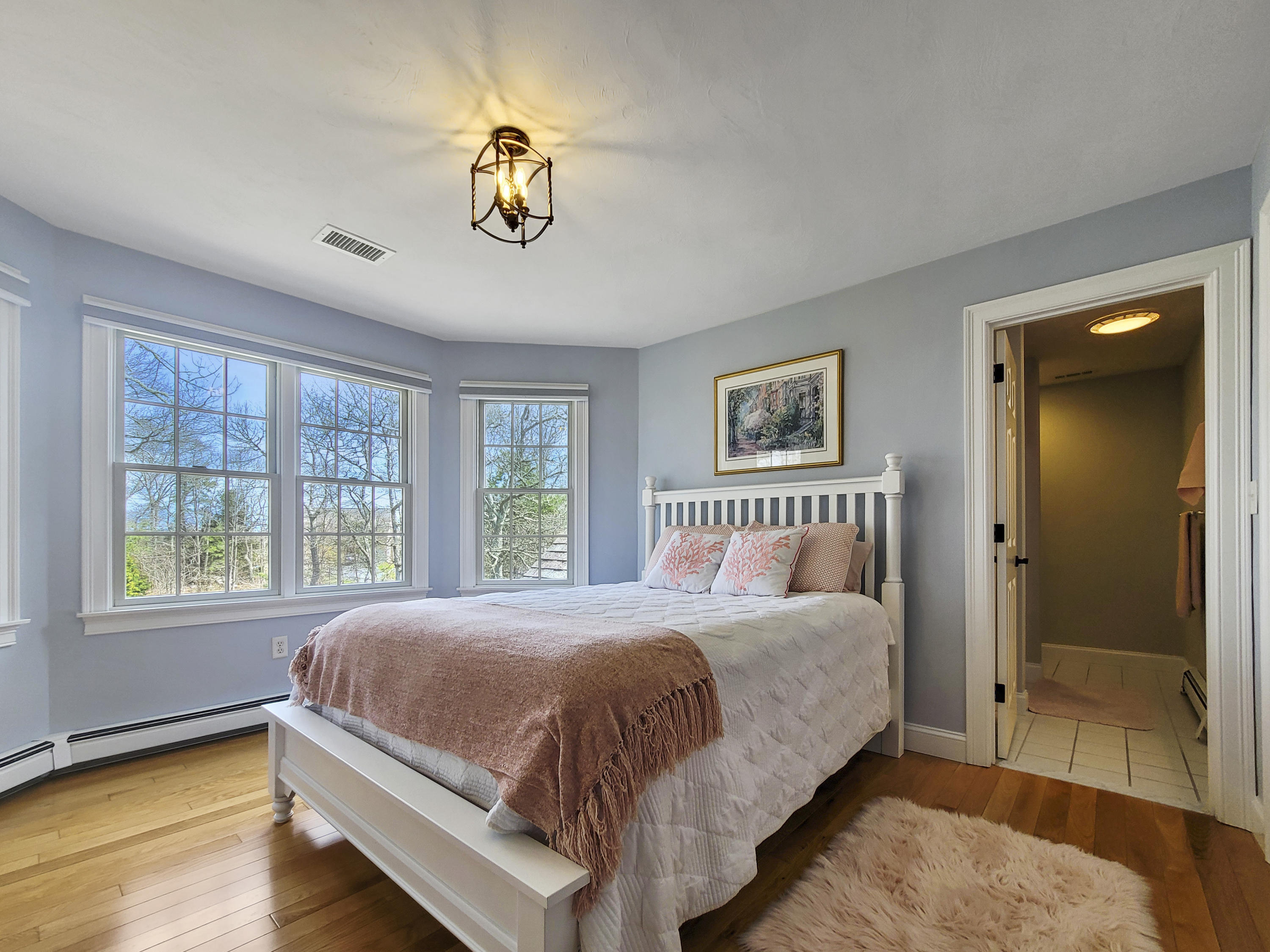 215 Cairn Ridge Road East Falmouth, MA 02536 - Photo 37 of 60 a bedroom with a large bed and a chandelier