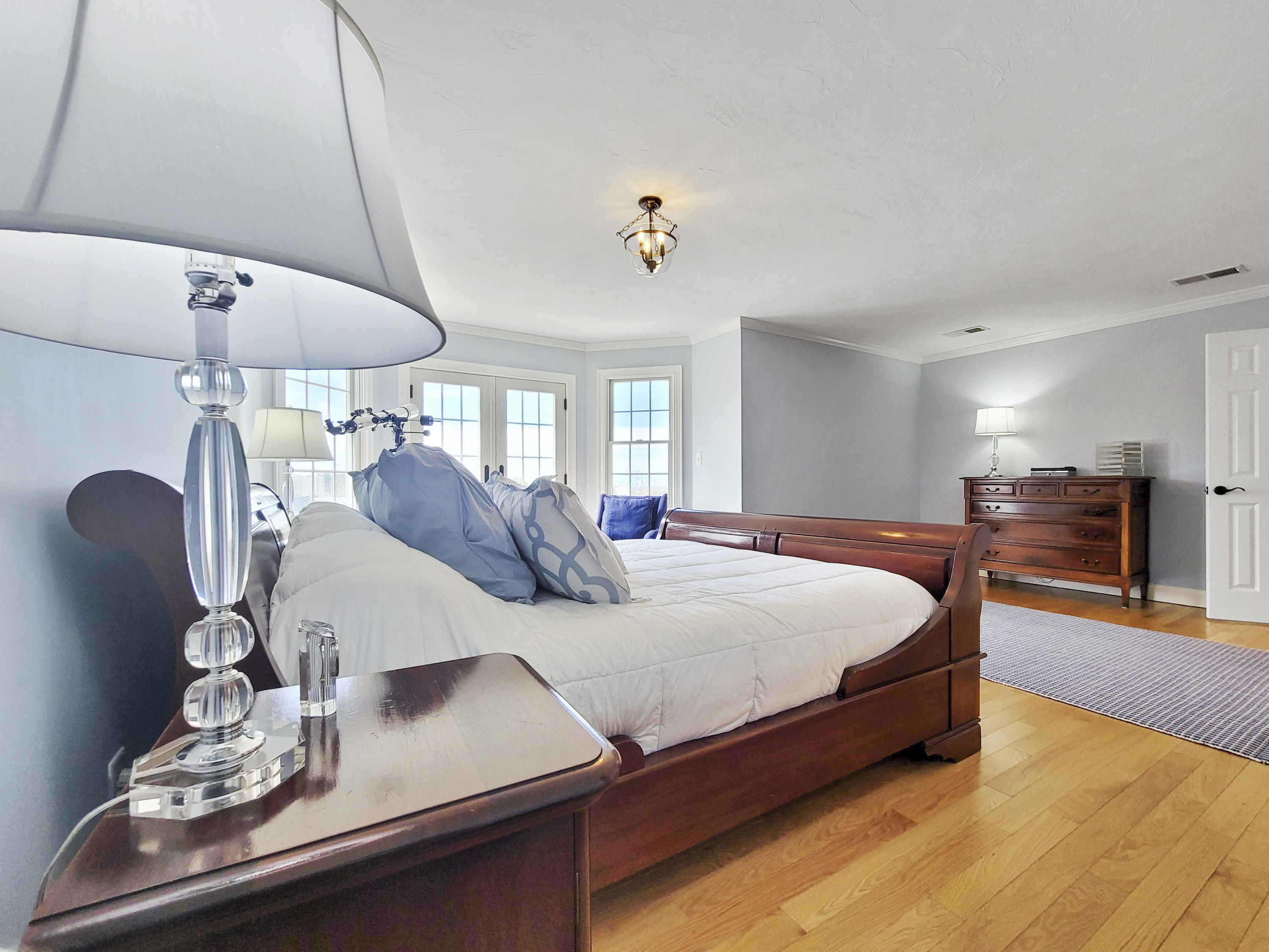 215 Cairn Ridge Road East Falmouth, MA 02536 - Photo 41 of 60 a bed room with a bed mirror and a chandelier