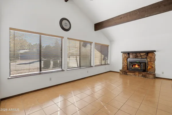 a view of an empty room with chandelier fan