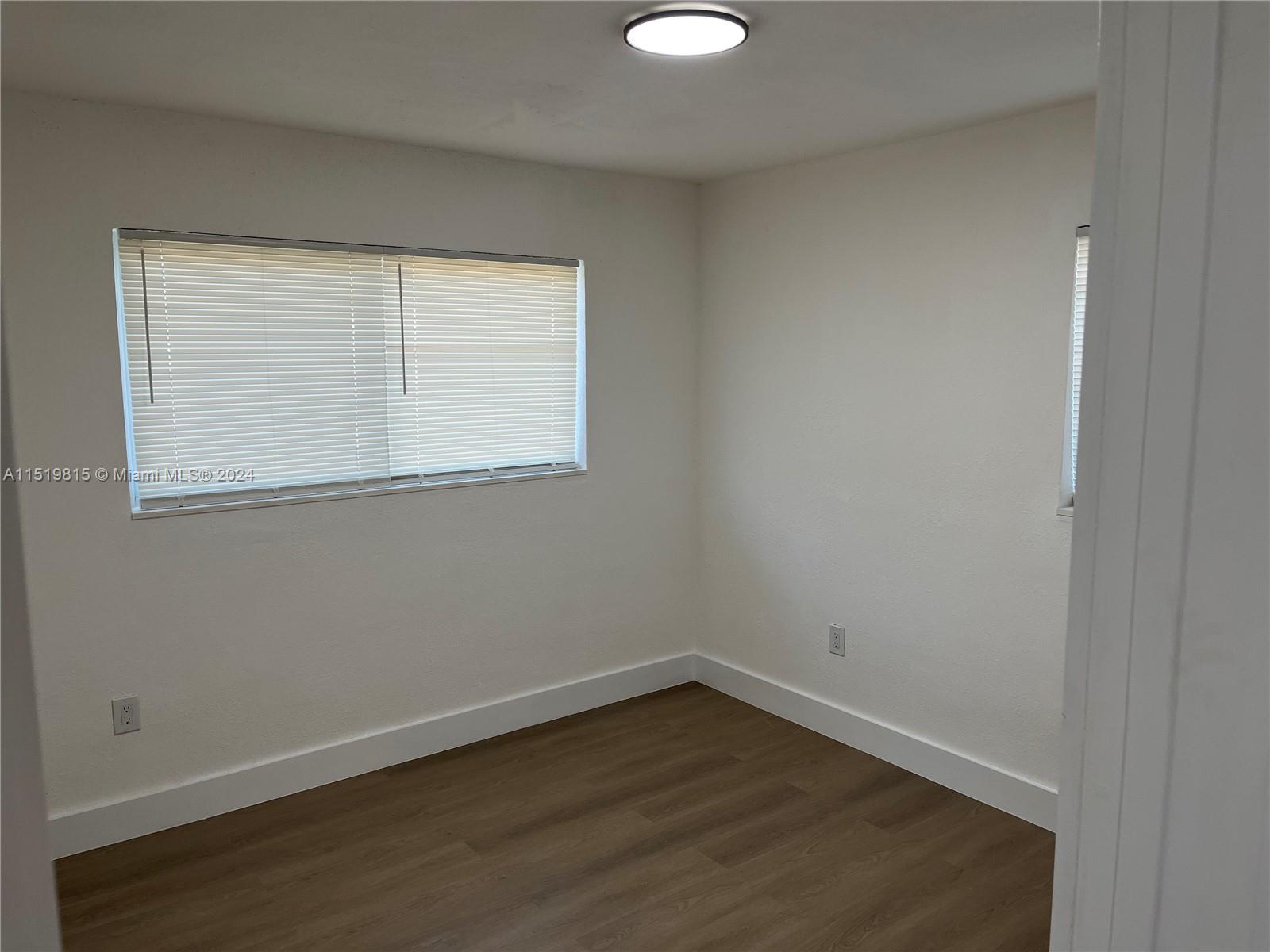10420 Southwest 42nd Street Miami, FL 33165 - Photo 11 of 17 an empty room with wooden floor and windows
