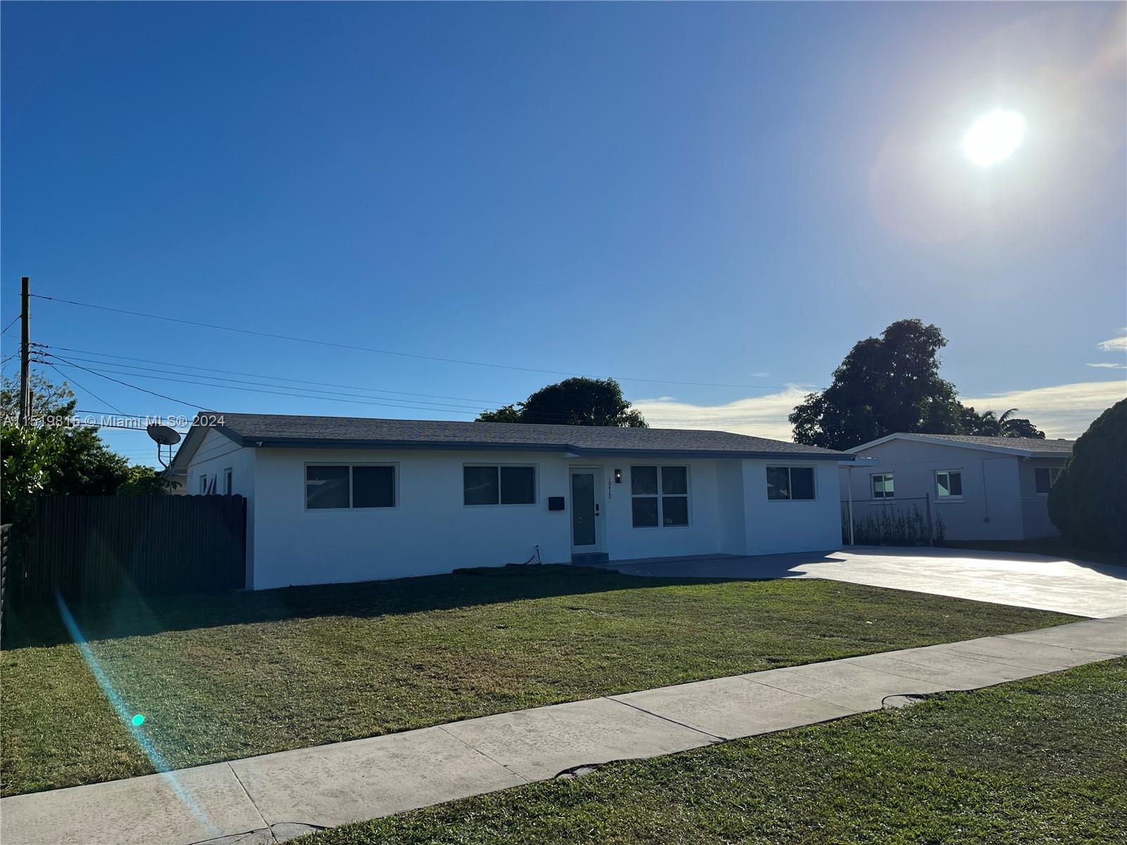 10420 Southwest 42nd Street Miami, FL 33165 - Photo 2 of 17 a front view of a house with a yard and garage