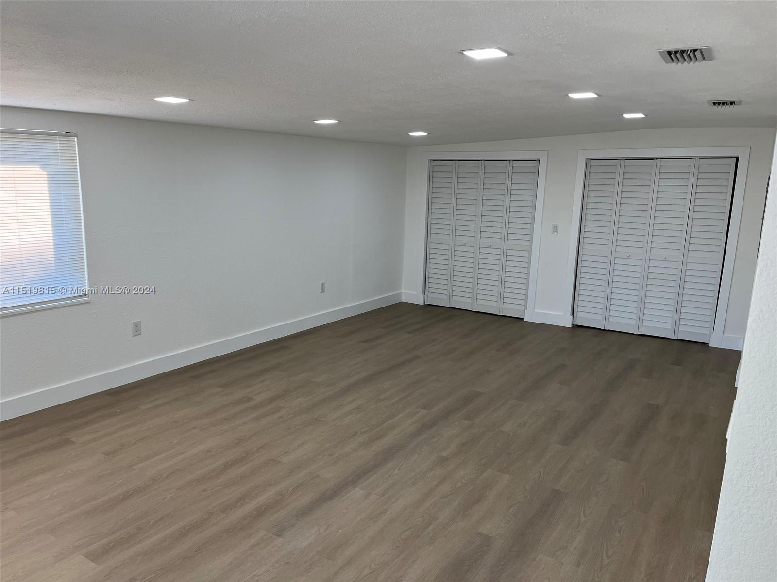 10420 Southwest 42nd Street Miami, FL 33165 - Photo 5 of 17 an empty room with wooden floor and windows